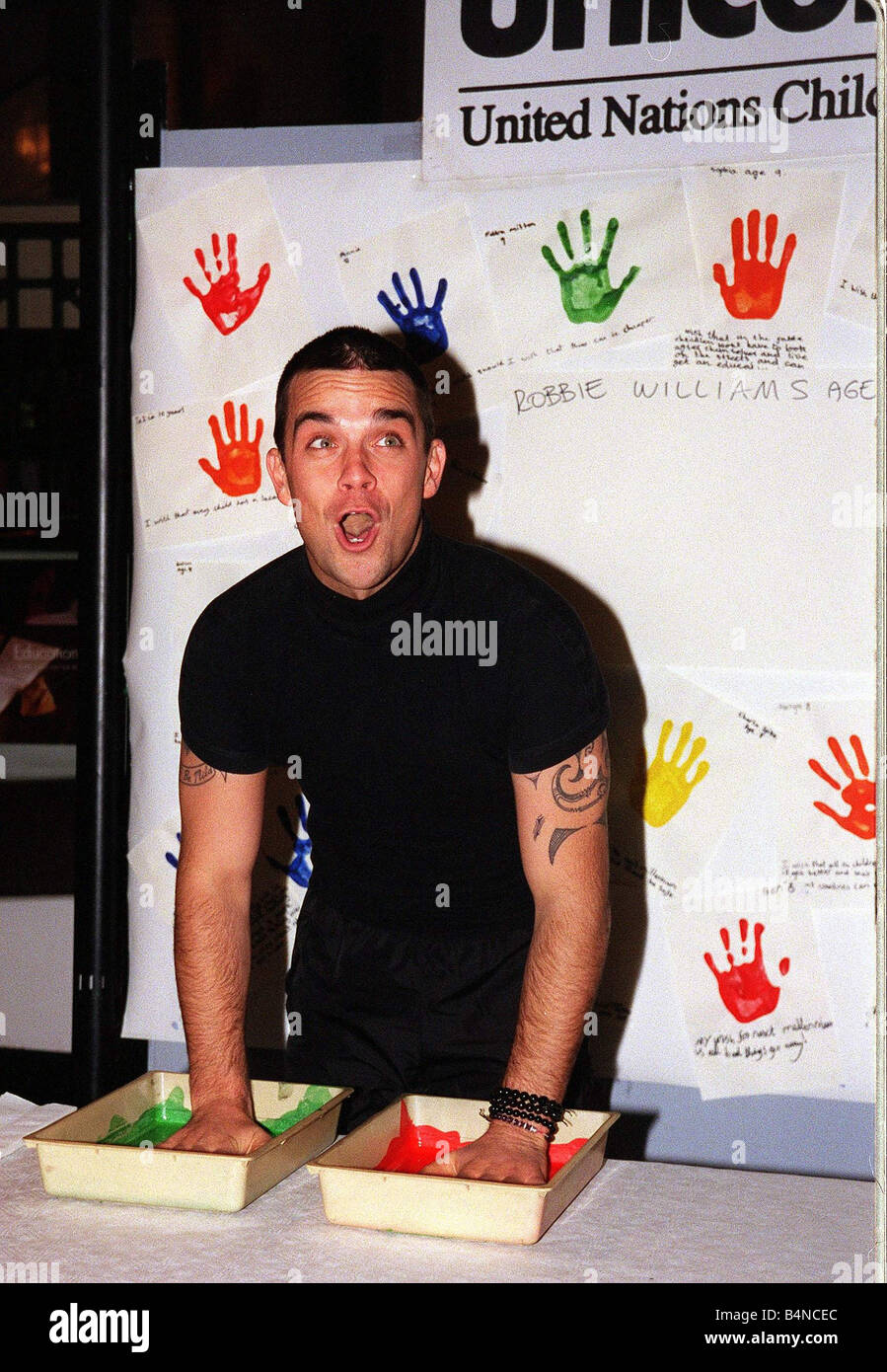 Robbie Williams fait salir les mains en novembre 1999 pour les droits des enfants à Bethnal Green Musée des enfants pour l'UNICEF trempant ses mains dans la peinture pour laisser sa main imprimer Banque D'Images