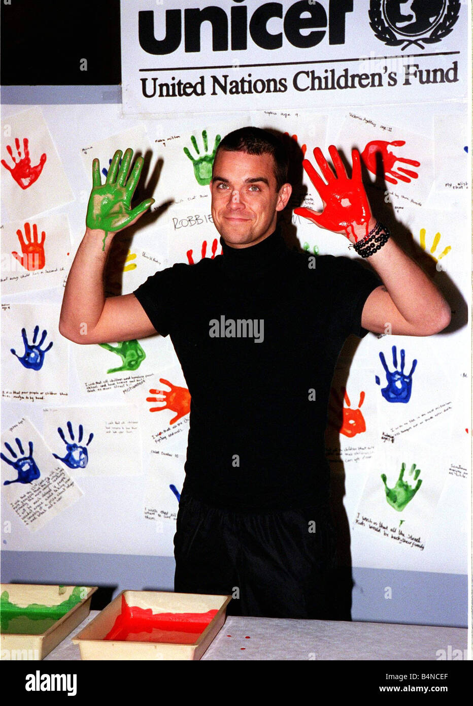 Robbie Williams fait salir les mains en novembre 1999 pour les droits des enfants à Bethnal Green Musée des enfants pour l'UNICEF trempant ses mains dans la peinture pour laisser sa main mdtgu Imprimer2 Banque D'Images