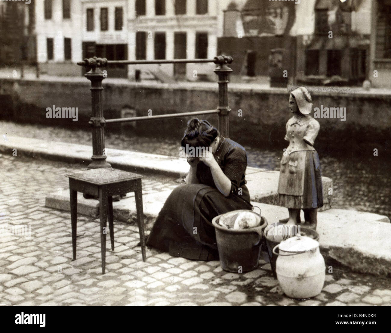 Anvers Belgique 1914 une femme pleure au bord de la route à côté d'une table quelques pots et casseroles et une lourde statue de pierre ses trésors du monde Août 1914 Banque D'Images