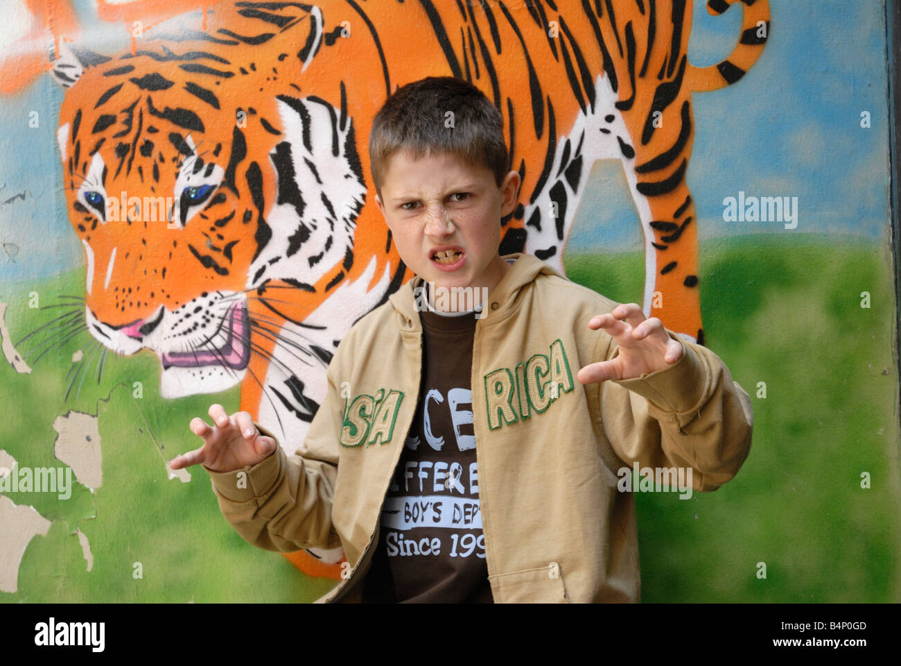 Un enfant faisant une janted un tigre dans l'arrière-plan Banque D'Images