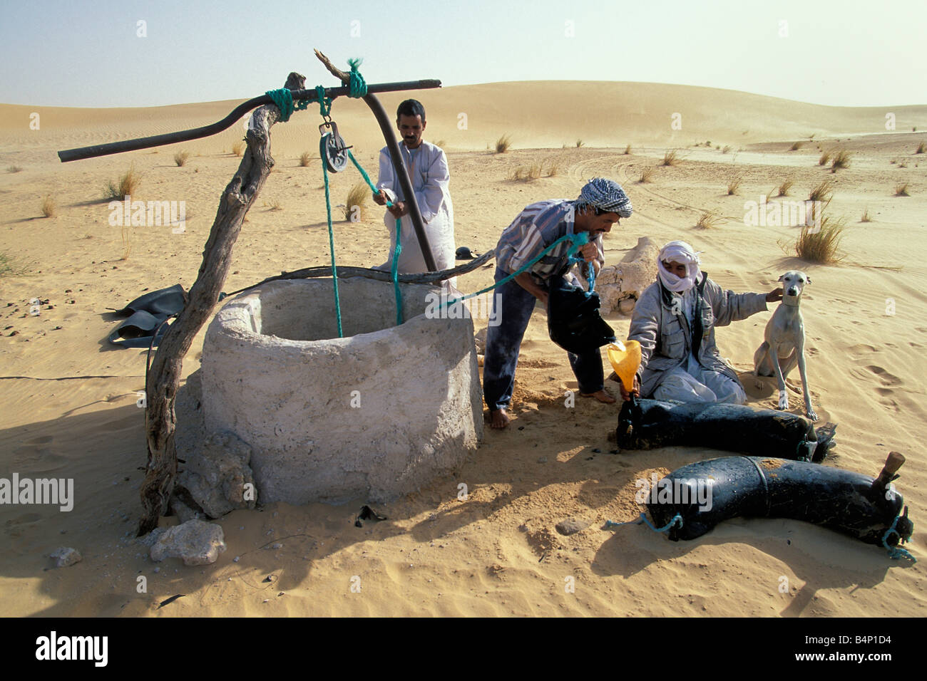 L'Algérie Touggourt hommes bédouins de prendre l'eau du puits du désert du Sahara Banque D'Images