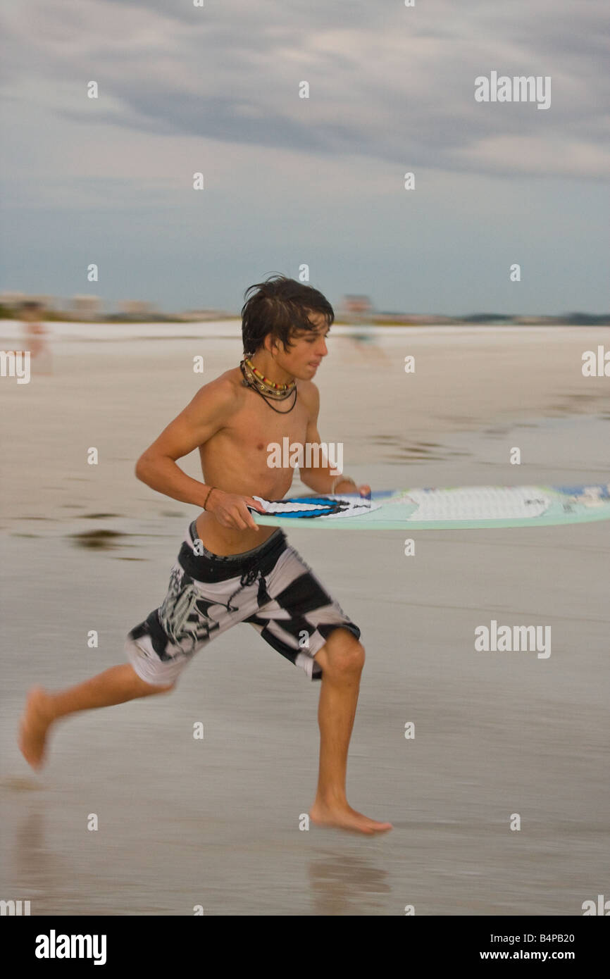 Skimboarding jeunesse le long d'une plage de Sarasota Banque D'Images