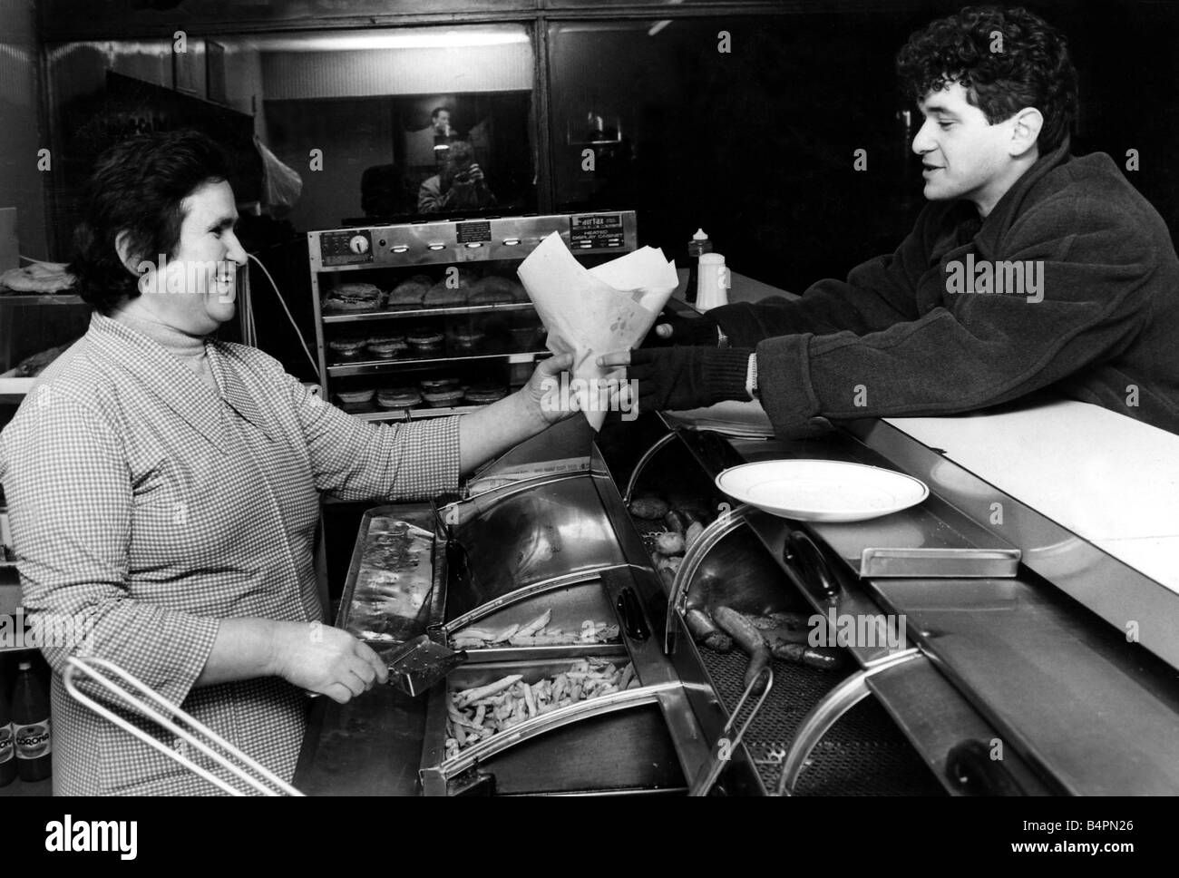 Mme Maria Stavri sert un client dans un poisson de Cardiff et chip shop Mars 1984 Banque D'Images
