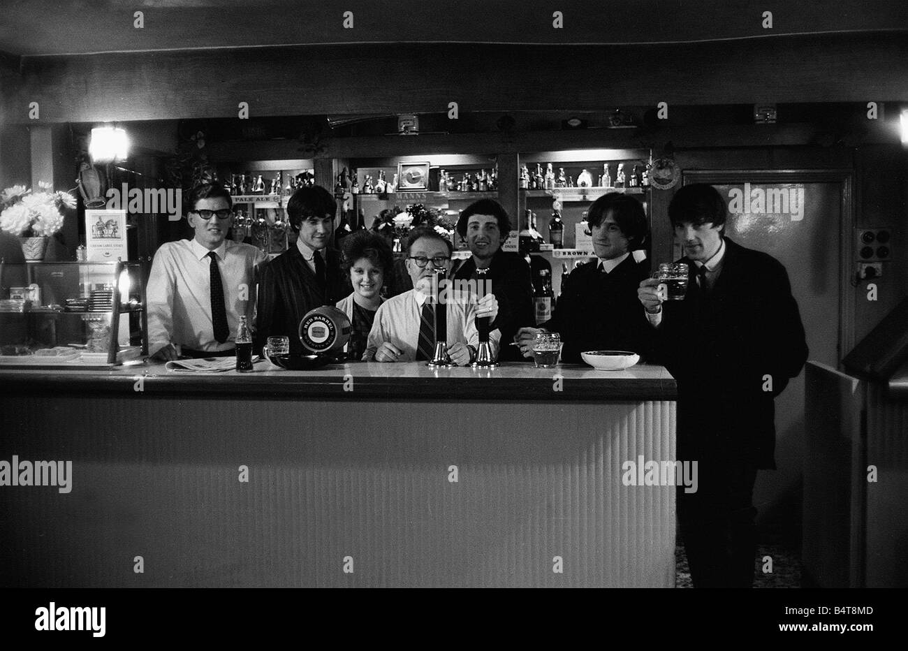 The Kinks pop group Septembre 1964 Ray Davies et Dave Davies dans un bar bénéficiant d'une pinte de bière avec le propriétaire Banque D'Images
