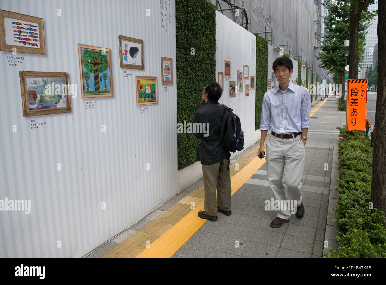 L'homme regardant la peinture dans une rue de Tokyo. Banque D'Images