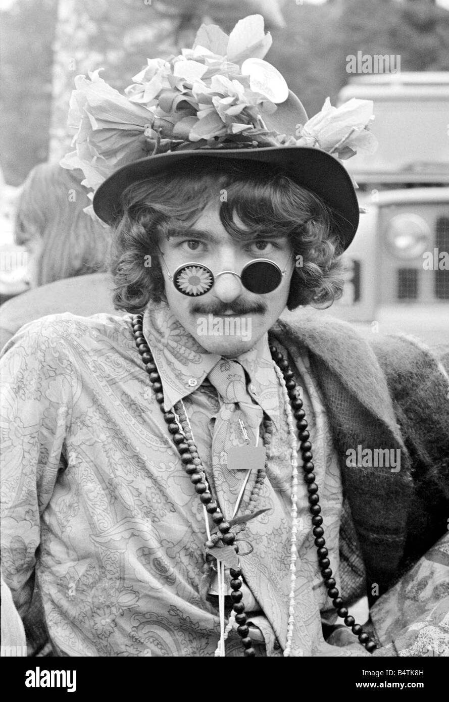 Flower Power festival à Woburn Abbey Août 1967 Un homme portant un hippie fleur hat et crazy lunettes de soleil avec un paisley shirt et un collier de perles regarde droit dans l'objectif de l'appareil photo des années 1960, la mode des vêtements hippies jeunesse culture La deuxième journée du festival mirrorpix Banque D'Images