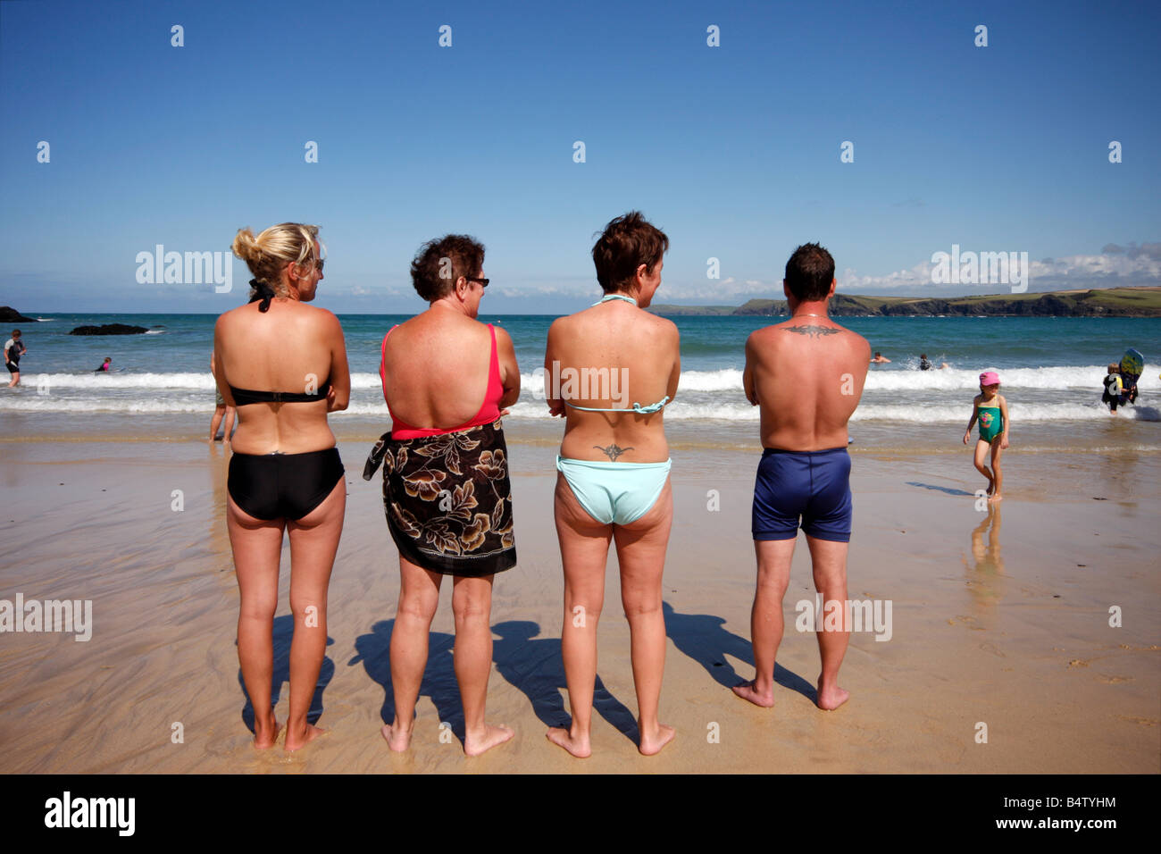 Groupe de personnes d'âge moyen sur la plage de Crantock Cornwall avec tatouages Banque D'Images