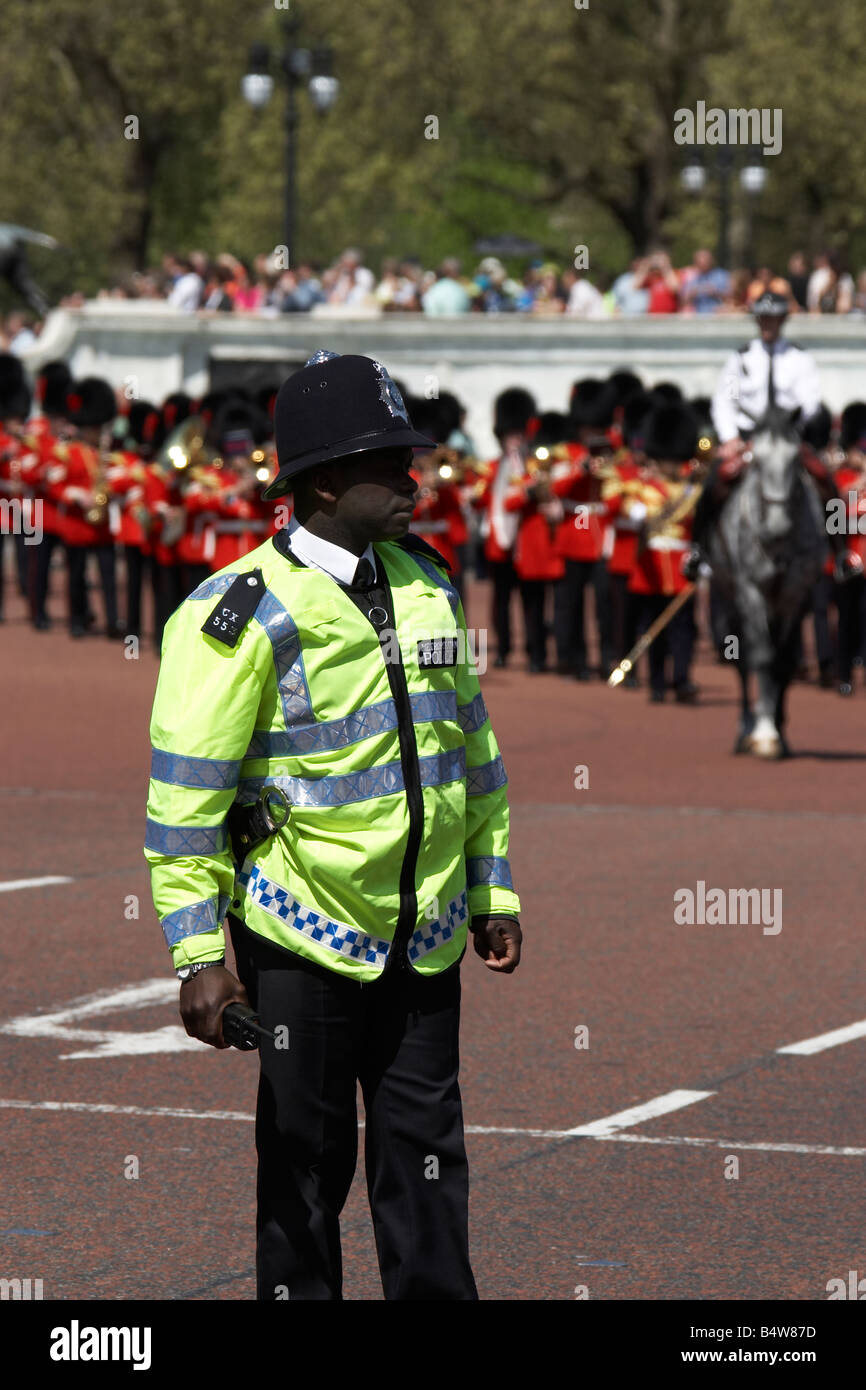 Agent de police métropolitaine s Garde à pied groupe jouant de militaires au cours de la relève de la garde au Palais de Buckingham en Angleterre Londres SW1 Banque D'Images