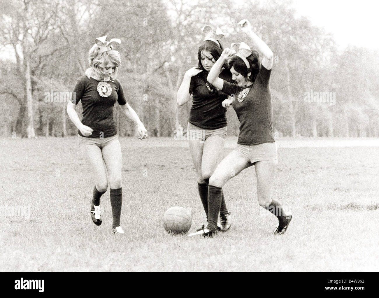 Bunny girls formation dans Hyde Park Londres Football lapins lapin Playboy portant des oreilles de lapin short kicking football vireur femmes filles Avril 1972 1970 Mirrorpix Banque D'Images