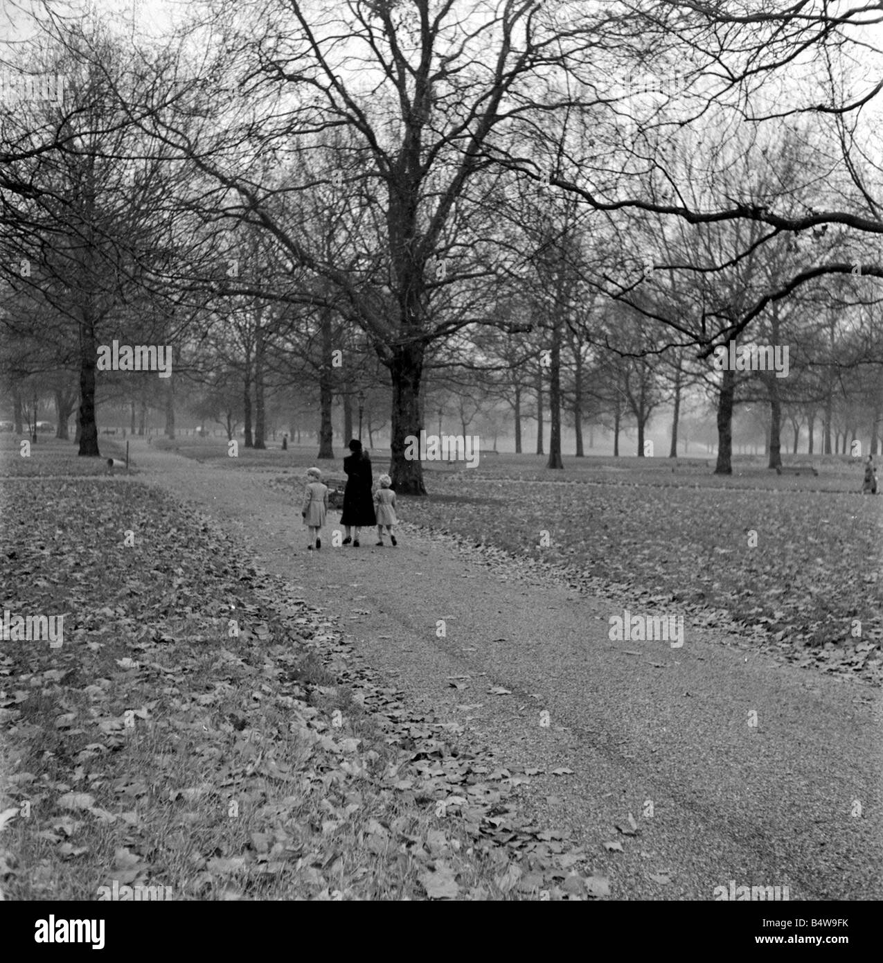 La princesse Anne et le Prince Charles promenade dans parc verdoyant avec leur gouvernante à leur retour au palais de Buckingham après la visite de la Reine Mère à Clarence House visites au parc n'étaient pas au courant des enfants royaux qui bénéficient d'un peu de liberté qu'ils ont été escortés de loin par un garde du corps royal de l'image a été prise par le photographe Arthur Sidey miroir qui avait été averti au sujet de la promenade dans le parc Arthur ne sachant pas quelle route les enfants royaux se a demandé à deux de ses collègues Dixie Dean et Bob Hope pour couvrir deux autres itinéraires possibles sur le parc Arthur coincé Banque D'Images