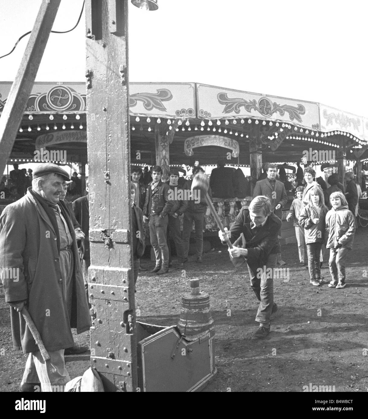 Foire de Pâques commun Hearsall, Coventry. Un jeune homme prend un swing sur le 'Ring the bell' fairground attraction.;28 Mai 1967 Banque D'Images