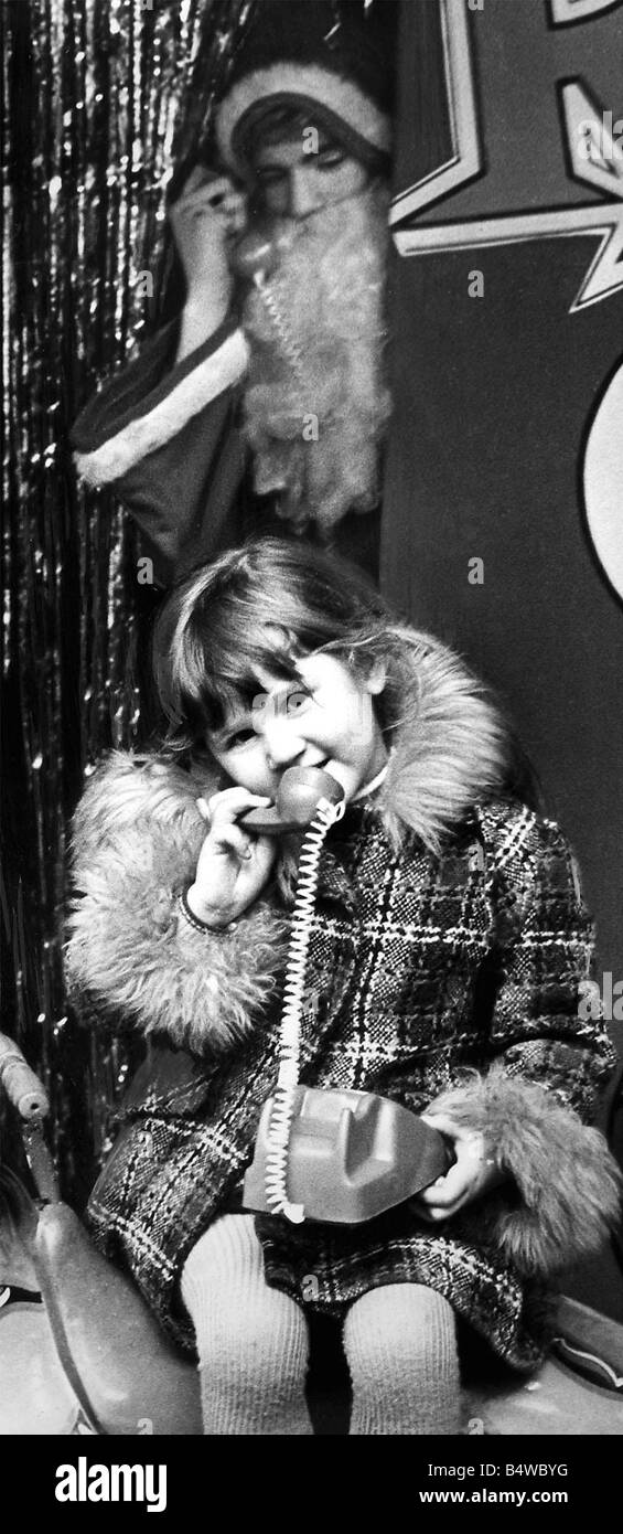 Amanda Louise Spencer âgée de cinq de Ashwood Terrasse Sunderland commande une robe de chaussons et d'une planche à repasser, tout en parlant au père Noël au téléphone en 1977 Banque D'Images