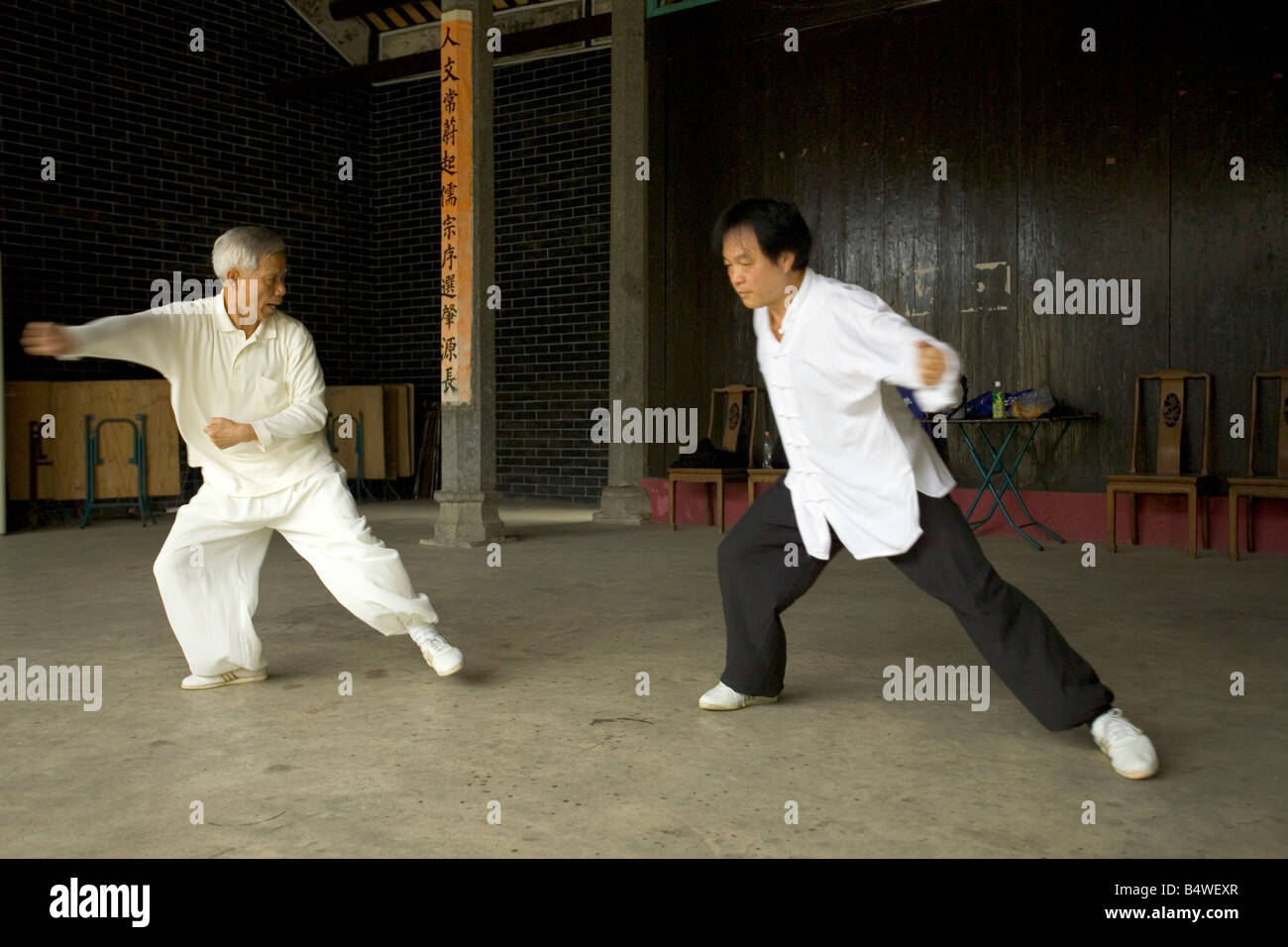 Deux hommes pratiquant l'art martial de taijiquan style Chen avec l'enseignant dans tout blanc. Banque D'Images