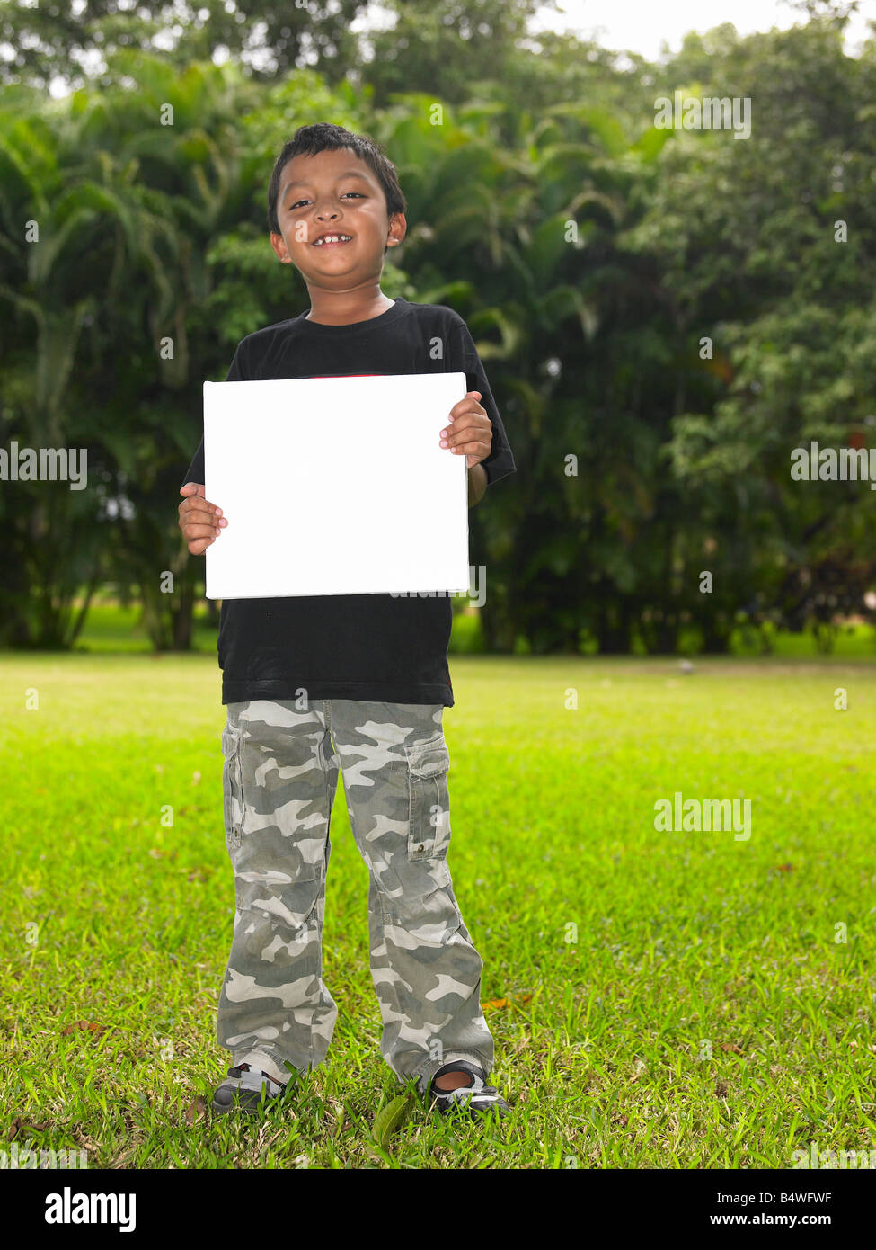 Asian boy avec une étiquette vierge dans le jardin Banque D'Images