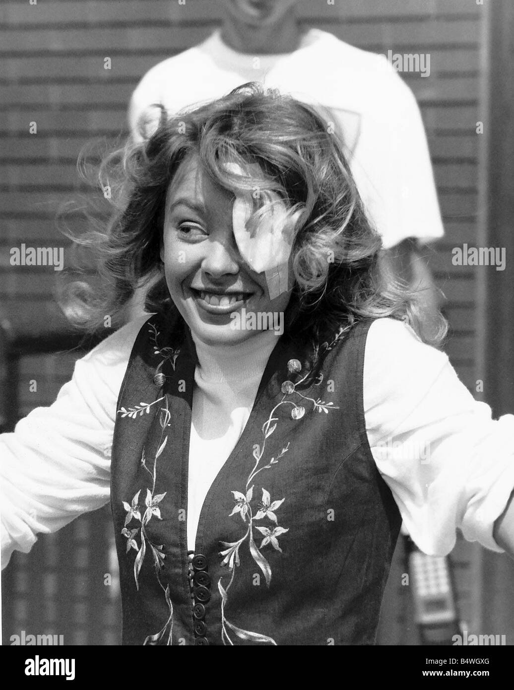 La chanteuse pop et actrice australienne Kylie Minogue qui raye accidentellement l'œil tout en essayant d'obtenir certains grit hors de son œil Juillet 1989 Banque D'Images