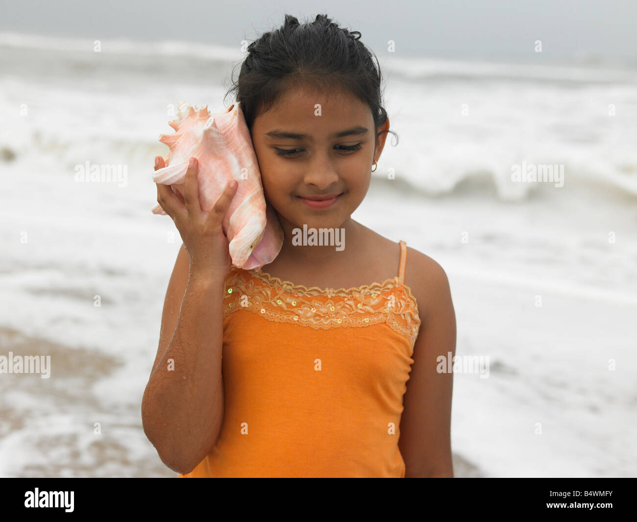 Asian girl écouter une conque Banque D'Images