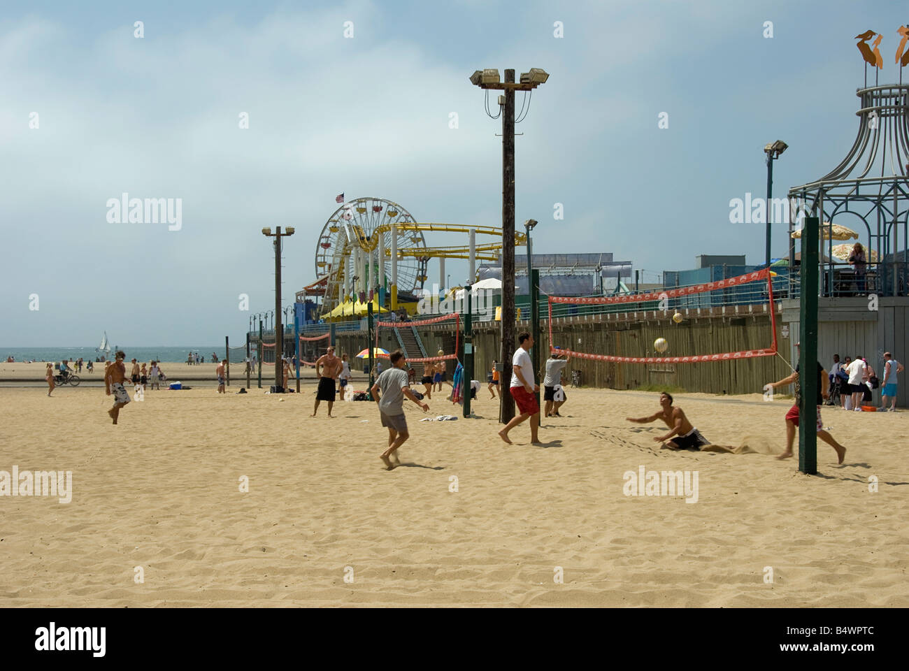 La plage de Santa Monica CA Personnes foule reposant, piscine, prendre le soleil et avoir l'amusement jouer des jeux, châteaux de sable, la marche, les vagues Banque D'Images
