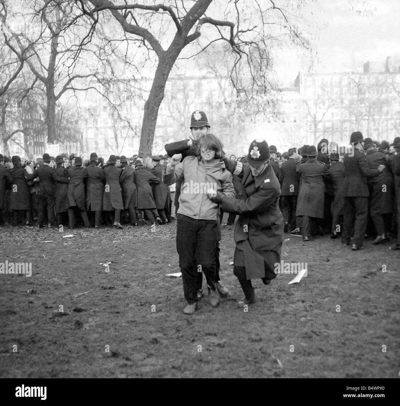 Un manifestant est emmenée lors d'émeutes à 'nous', de l'Ambassade, Grosvenor 'carre' sur le conflit du Vietnam. Mars 1968 Banque D'Images
