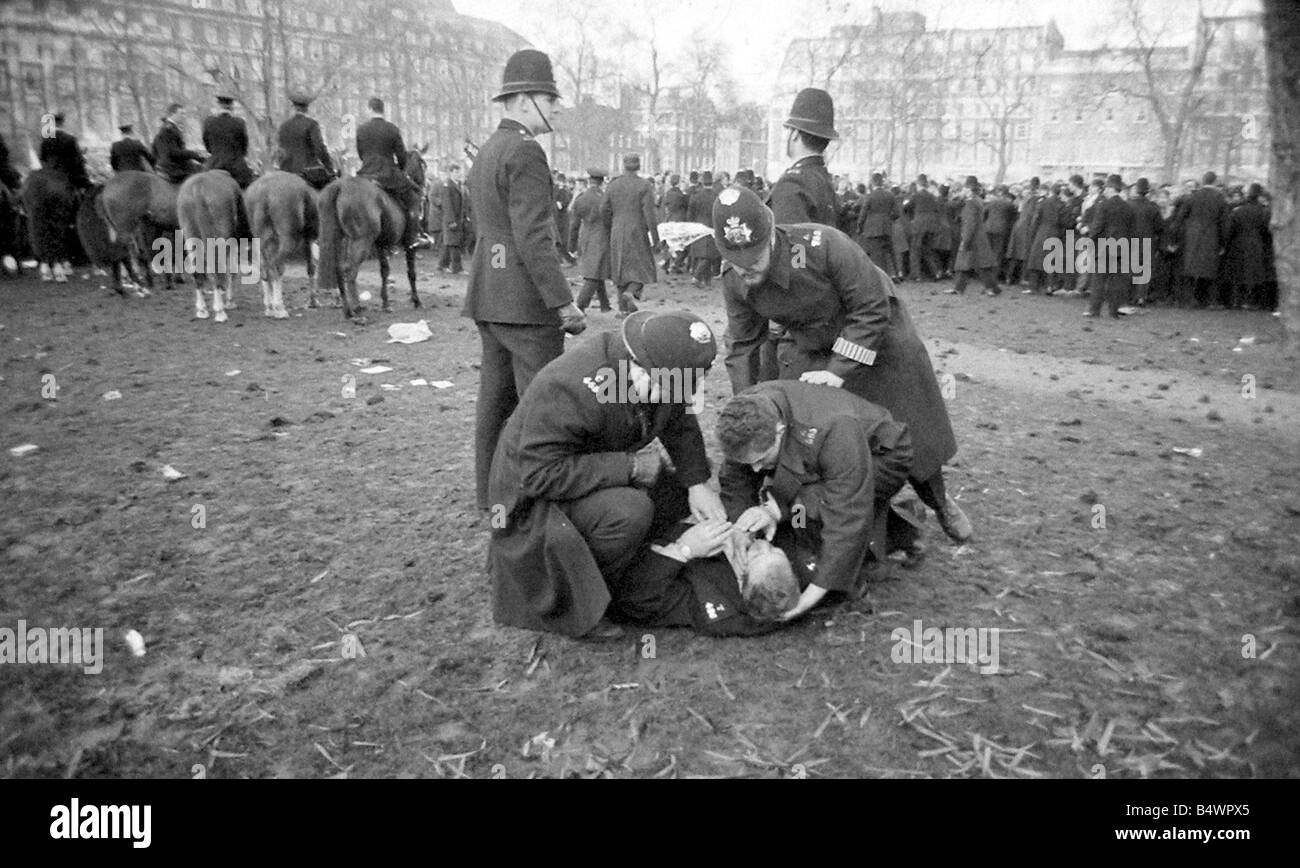 Un policier blessé est aidé par ses collègues policiers lors d'émeutes à l'ambassade des États-Unis, Grosvenor Square, sur le conflit du Vietnam.;Mars 1968;Y2619-21A ; Banque D'Images