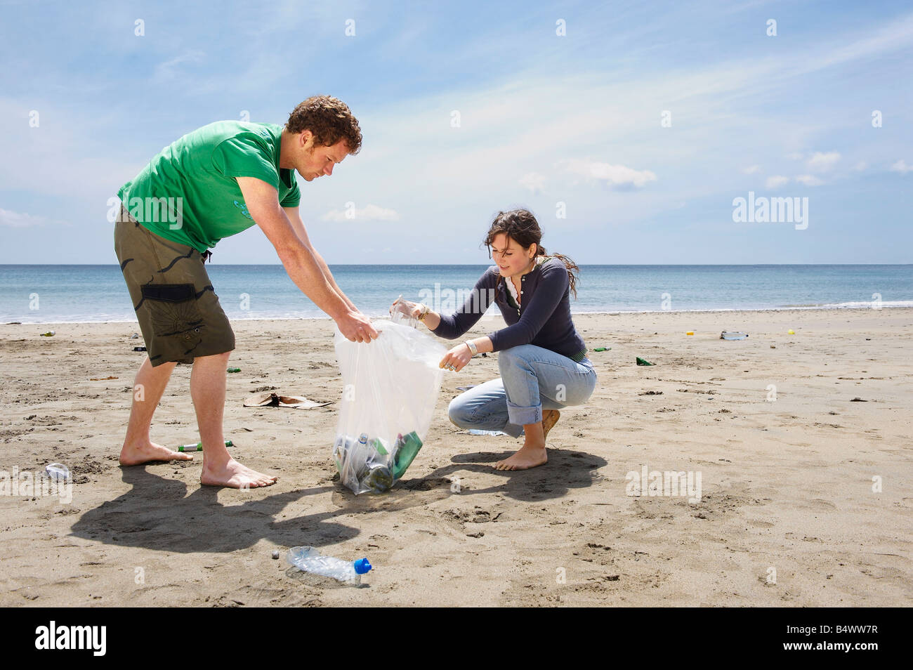 La collecte des déchets jeune couple on beach Banque D'Images