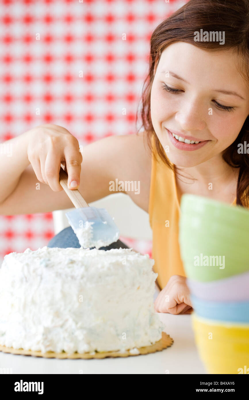 Teenage girl frosting cake Banque D'Images