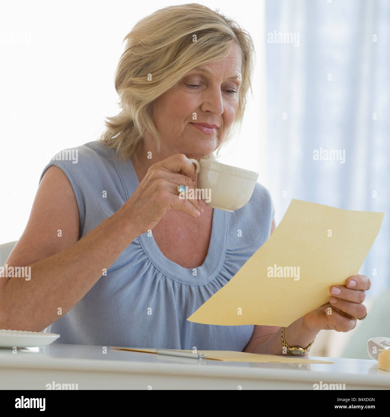 Femme lisant une lettre à la maison Banque D'Images