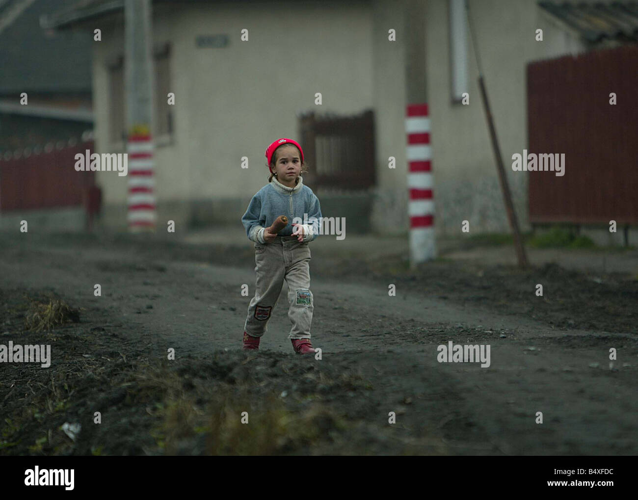Copsa Mica Roumanie Novembre 2006 Copsa Mica plus polluées d'Europe, place une petite fille va à la maison avec une carotte le long de la rue noire à côté de l'ancienne entreprise carbone Banque D'Images