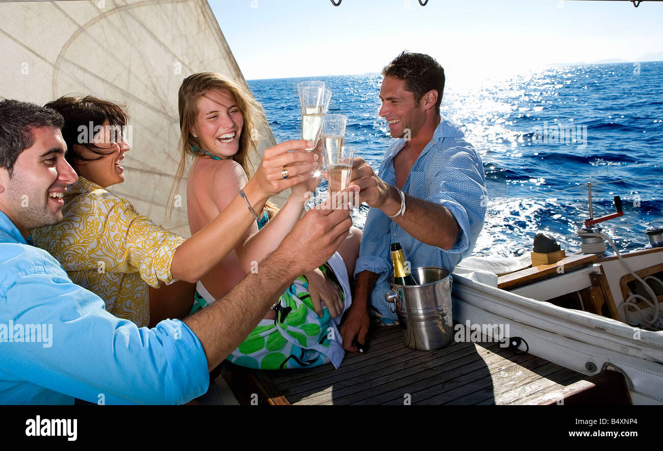 Deux couples de faire un toast sur voilier Banque D'Images