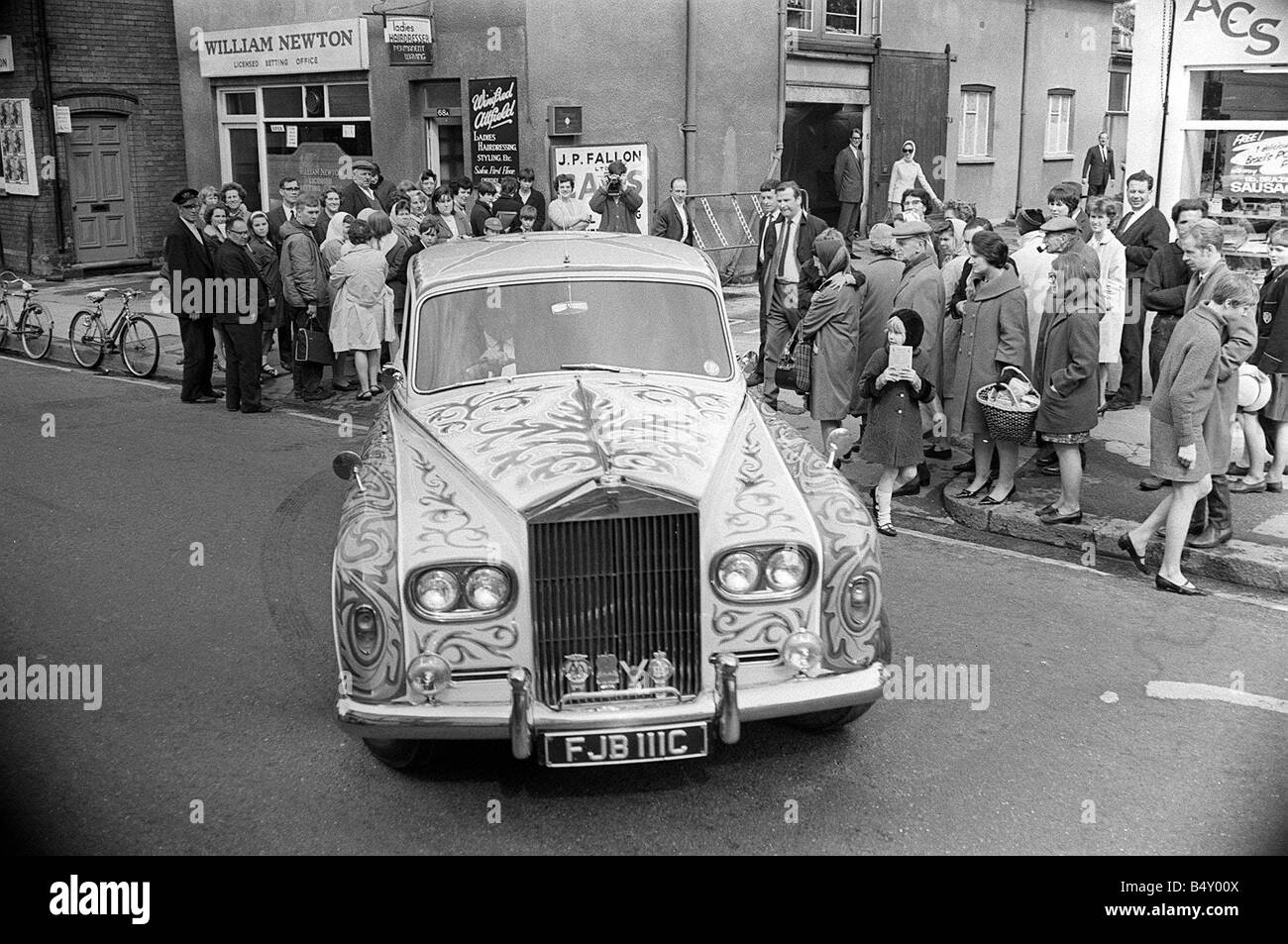 John Lennon The Beatles Pop Group Rolls Royce Mai 1967 quitte l'atelier de peinture de voiture décorée des foules de gens regarder la voiture chasse Banque D'Images