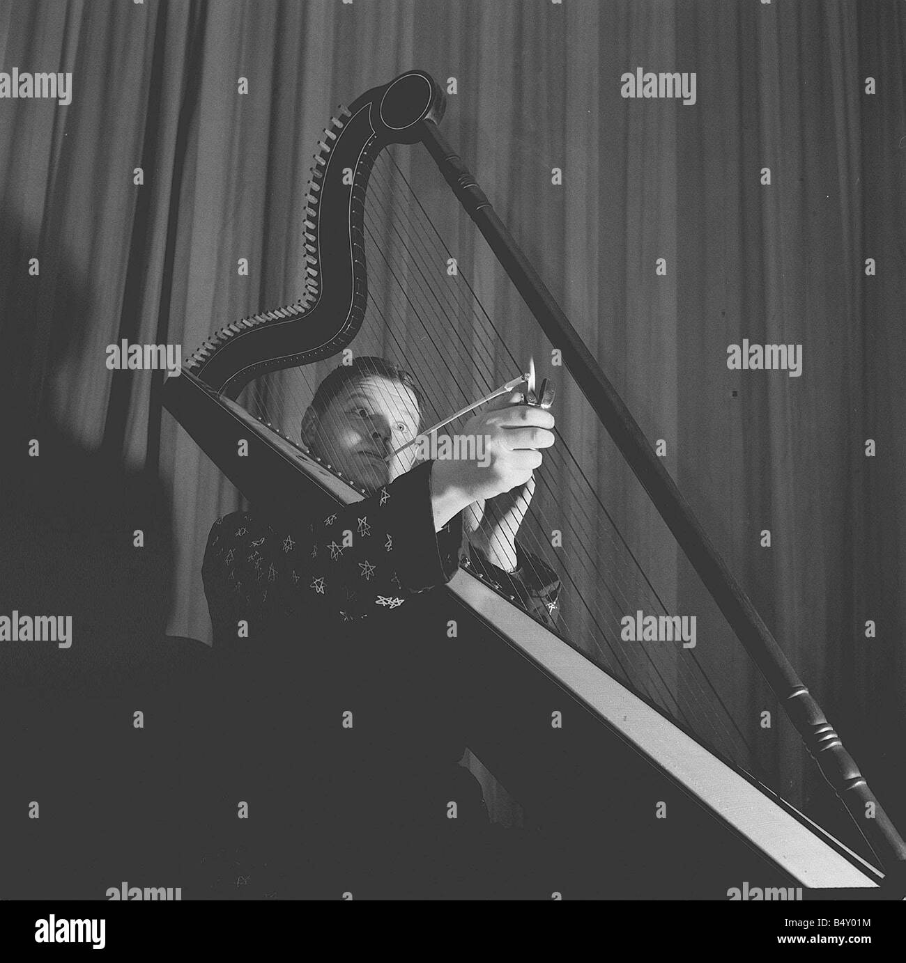 Harpe jouant Benny Hill 20 6 62 Q1526 Case 25 Le comédien enny Hill de l'affichage d'une façon plutôt originale de profiter d'une ciggarette tout en jouant de la harpe Y2K2 dtgu la renommée le 21 janvier marque l'anniversaire de la naissance de l'humoriste britannique Alfred Hill mieux connu sous le nom de Benny Hill il est apparu dans la comédie revues sur scène à la radio et en 1949 sur l'émission de télévision Salut en 1955 il a commencé le Benny Hill Show avec des sketches et des chansons de la butée et poitrine school d'humour anglais Hill semble aussi occasionnellement dans des films comme Chitty Chitty Bang Bang dans les années 1970, Le Benny Hill Show a à Banque D'Images