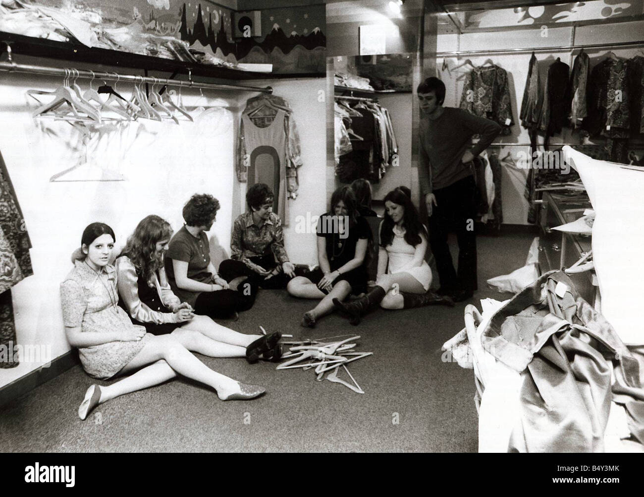 Les femmes se reposer après une dure journée dans shop 1968 jeunes travailleurs boutique fermeture fatigué les cintres des boutiques de vêtements shop shopping Banque D'Images