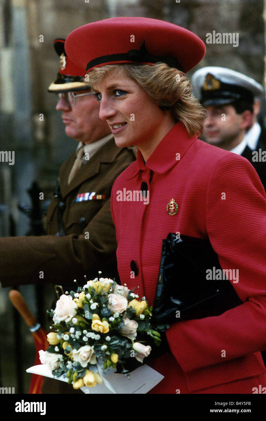 La princesse Diana Princesse de Galles portant costume rouge et red hat à bande noire tenant un sac noir et un bouquet de fleurs 1989 Banque D'Images