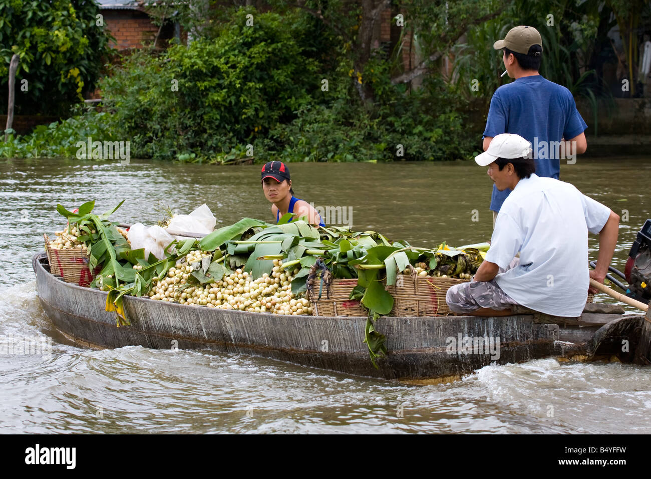 Vendeur sur le bateau en bois le long de la rivière sur le marché flottant Banque D'Images