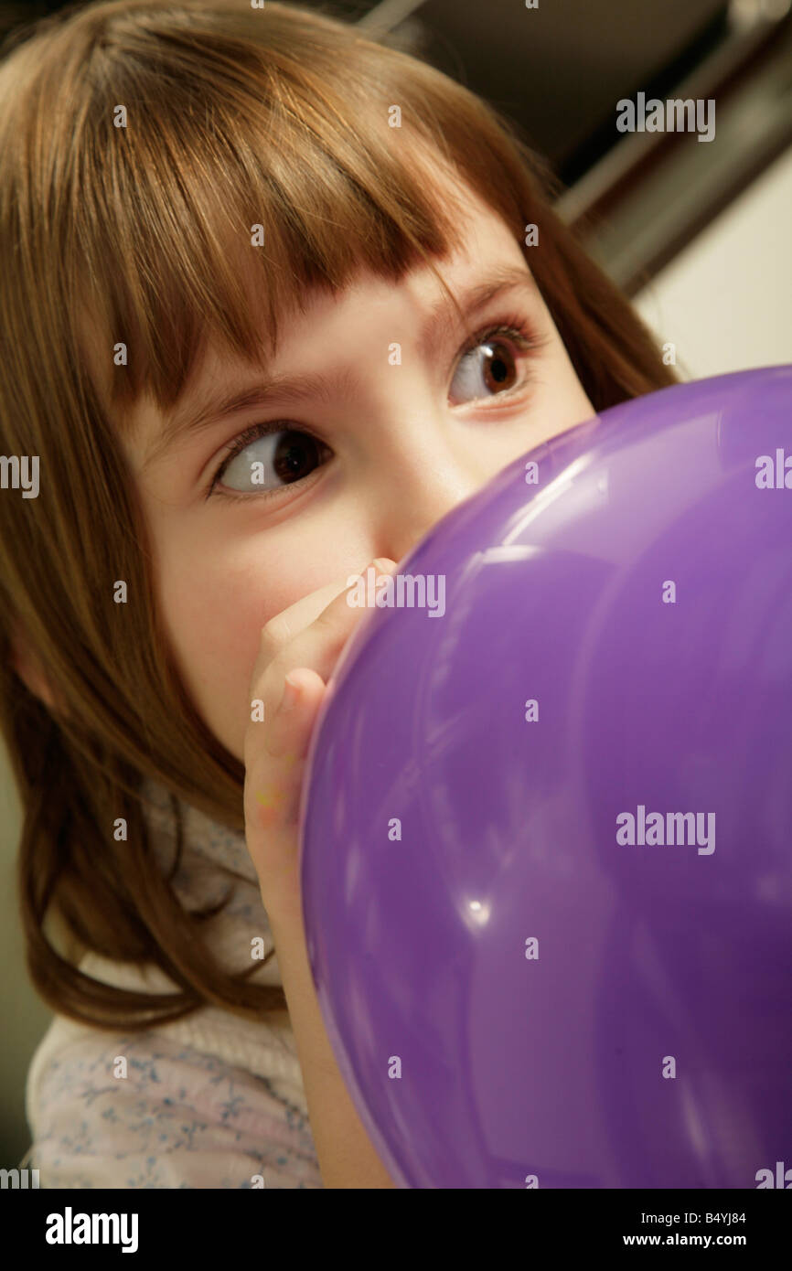 Petite fille de gonfler un ballon Banque D'Images