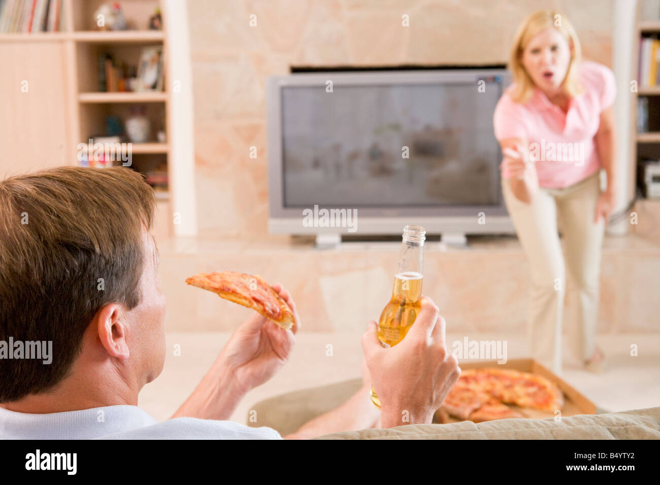 Femme Mari disant Off pour boire de la bière et manger des pizzas Banque D'Images