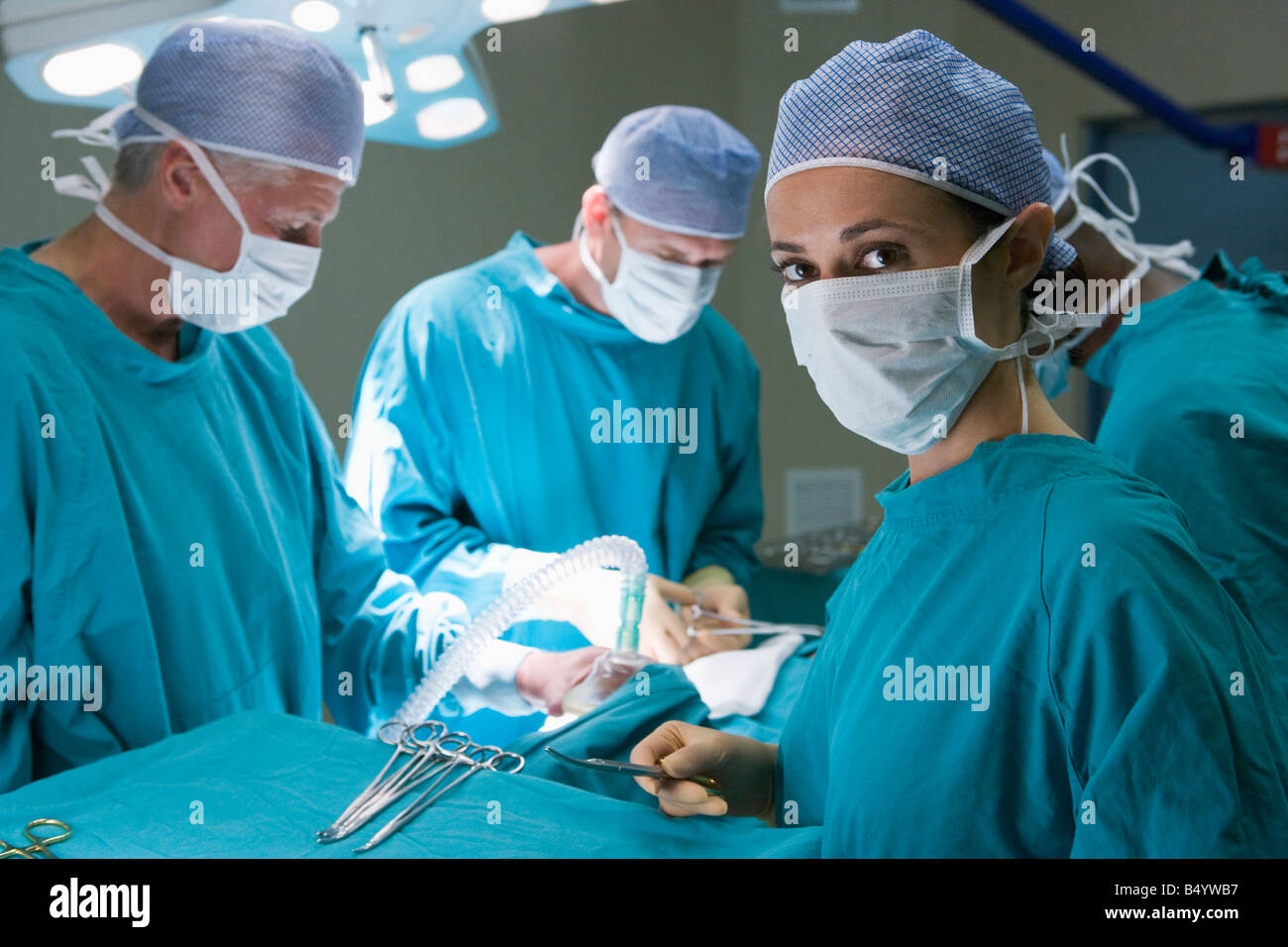 Quatre chirurgiens de se préparer à opérer sur un patient Banque D'Images