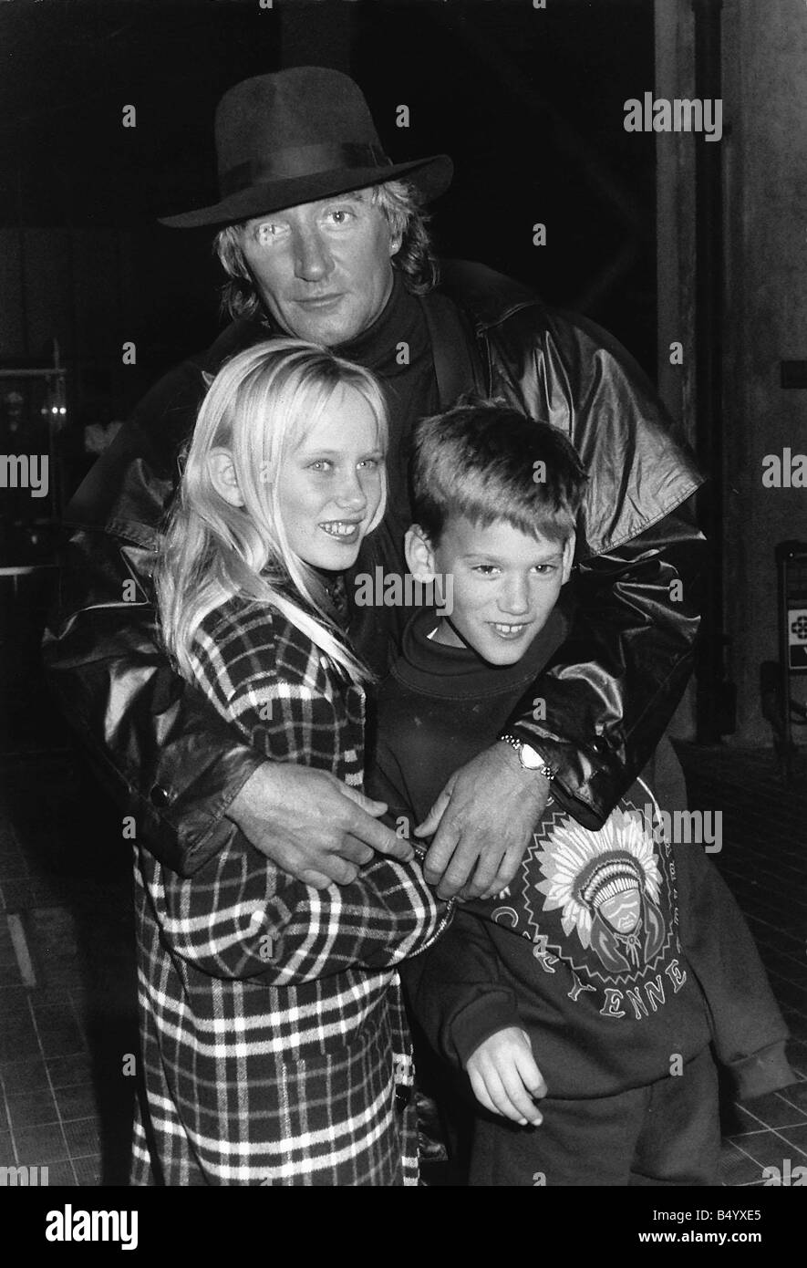 Rod Stewart avec leur fille Kimberley Stewart et 10 fils, Sean Stewart 9 Alana leur maman les a envoyés à partir de Los Angeles et ils ont été accueillis par leur père à l'aéroport d'Heathrow pour qu'ils puissent passer Noël en décembre 1989 Rod Stewart enfants famille hugging Banque D'Images