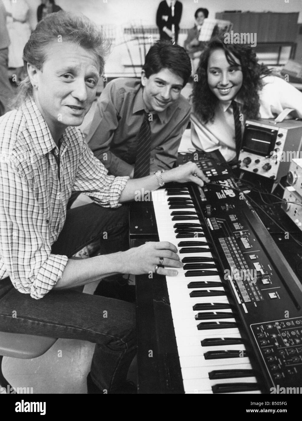 Chanteur auteur-compositeur John Miles avec Steven Henderson et Julie Miah élèves dans Hedworthfield Comprehensive School Jarrow au cours de sa visite d'un atelier de musique 11 05 89 Banque D'Images