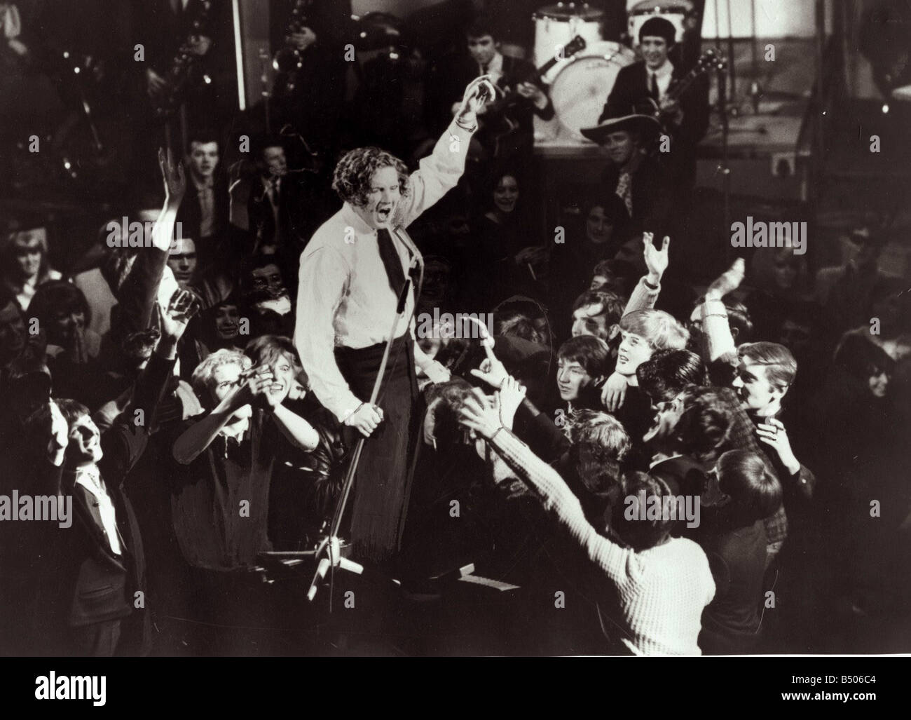 Jerry Lee Lewis chanteur sur scène entouré de fans chanter Banque D'Images
