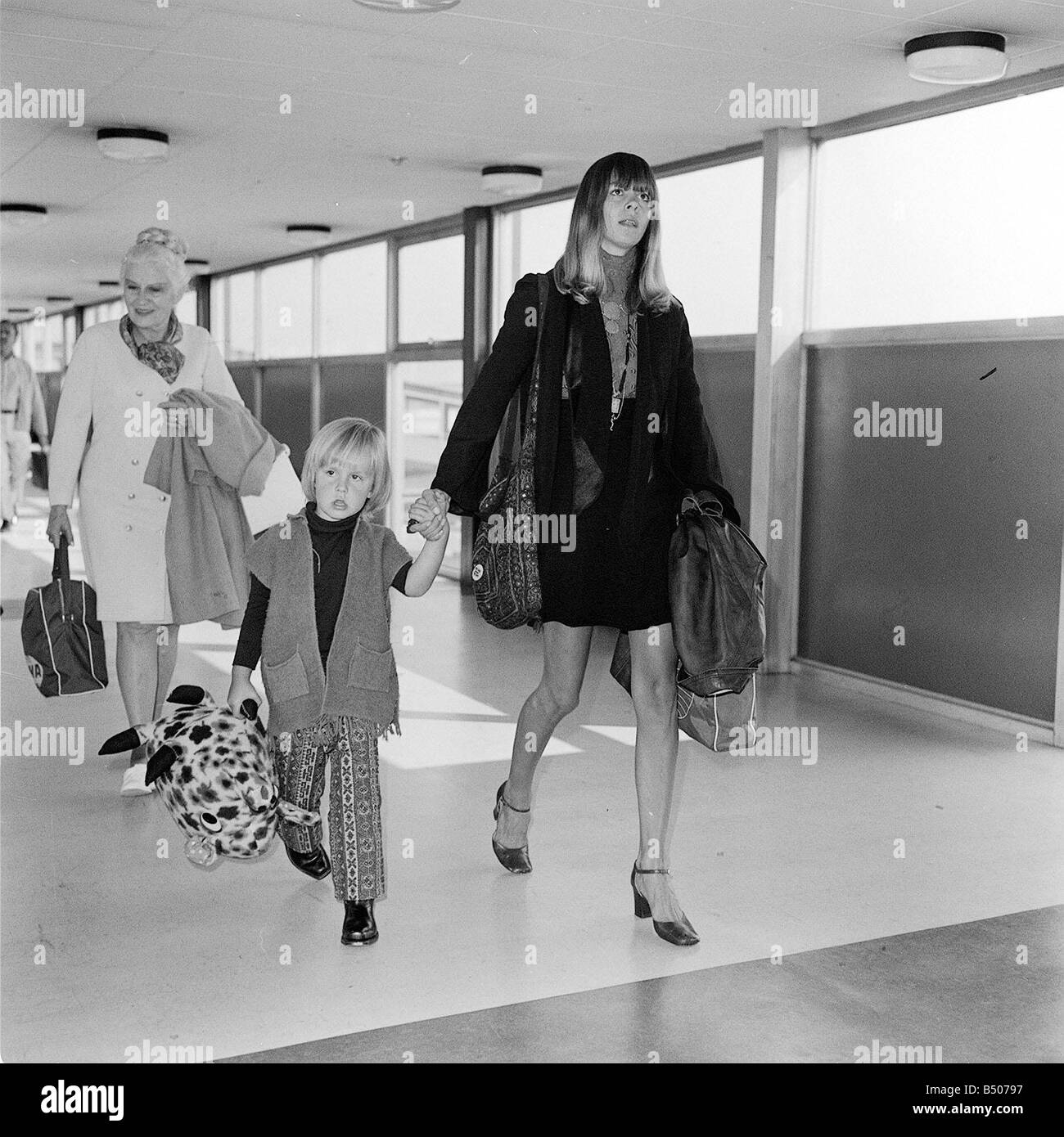 Linda Lawrence une fois petite amie de Brian Jones des Rolling Stones arrivant à l'aéroport d'Heathrow avec son fils par Brian Julian portant un ours en peluche Banque D'Images