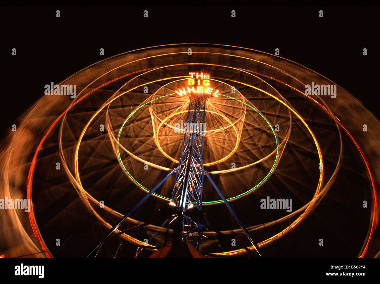 Une roue qui tourne brille contre le ciel de nuit au spectacle de Cairns Banque D'Images