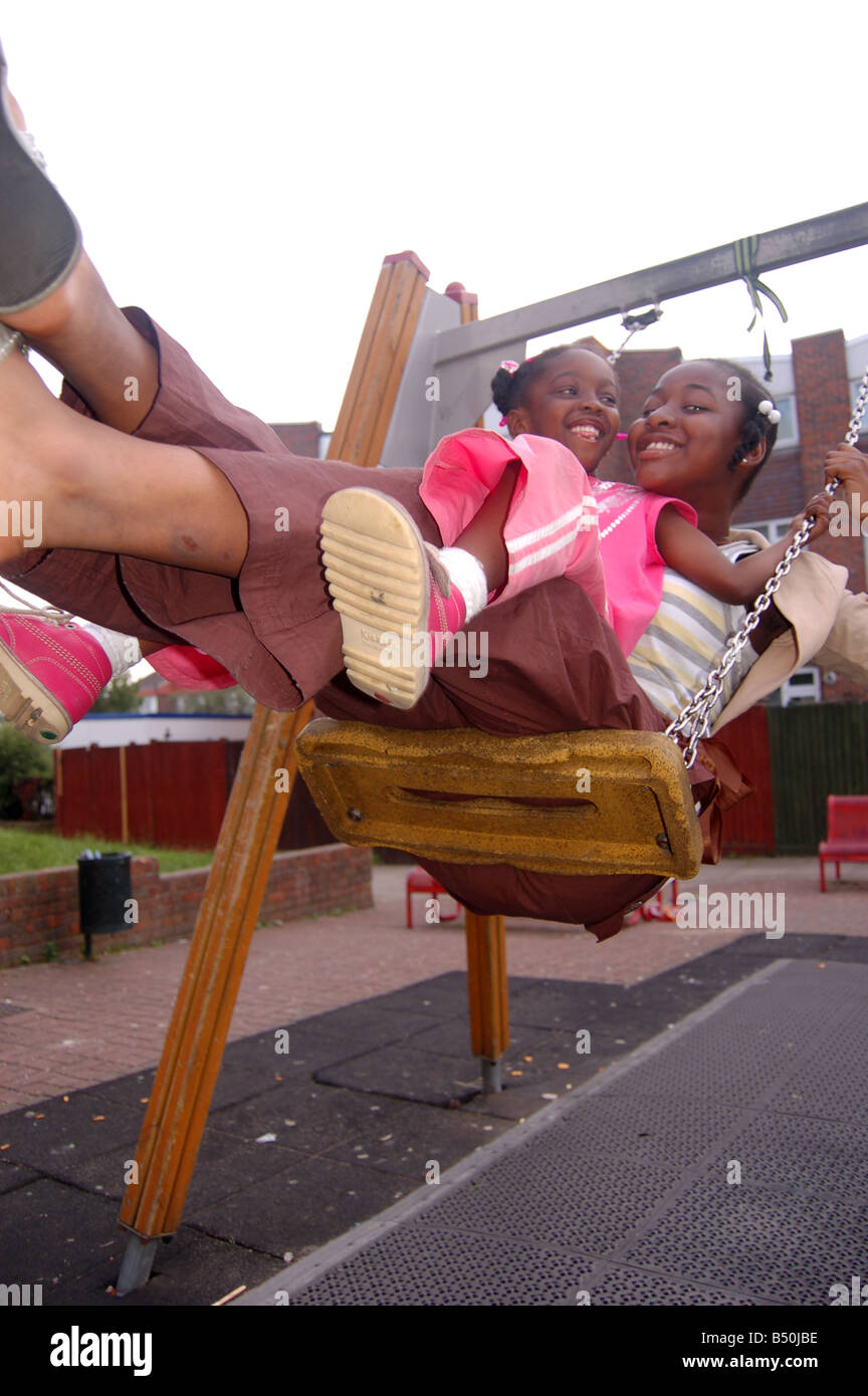 Smiling afro-caraïbes enfants on swing Banque D'Images