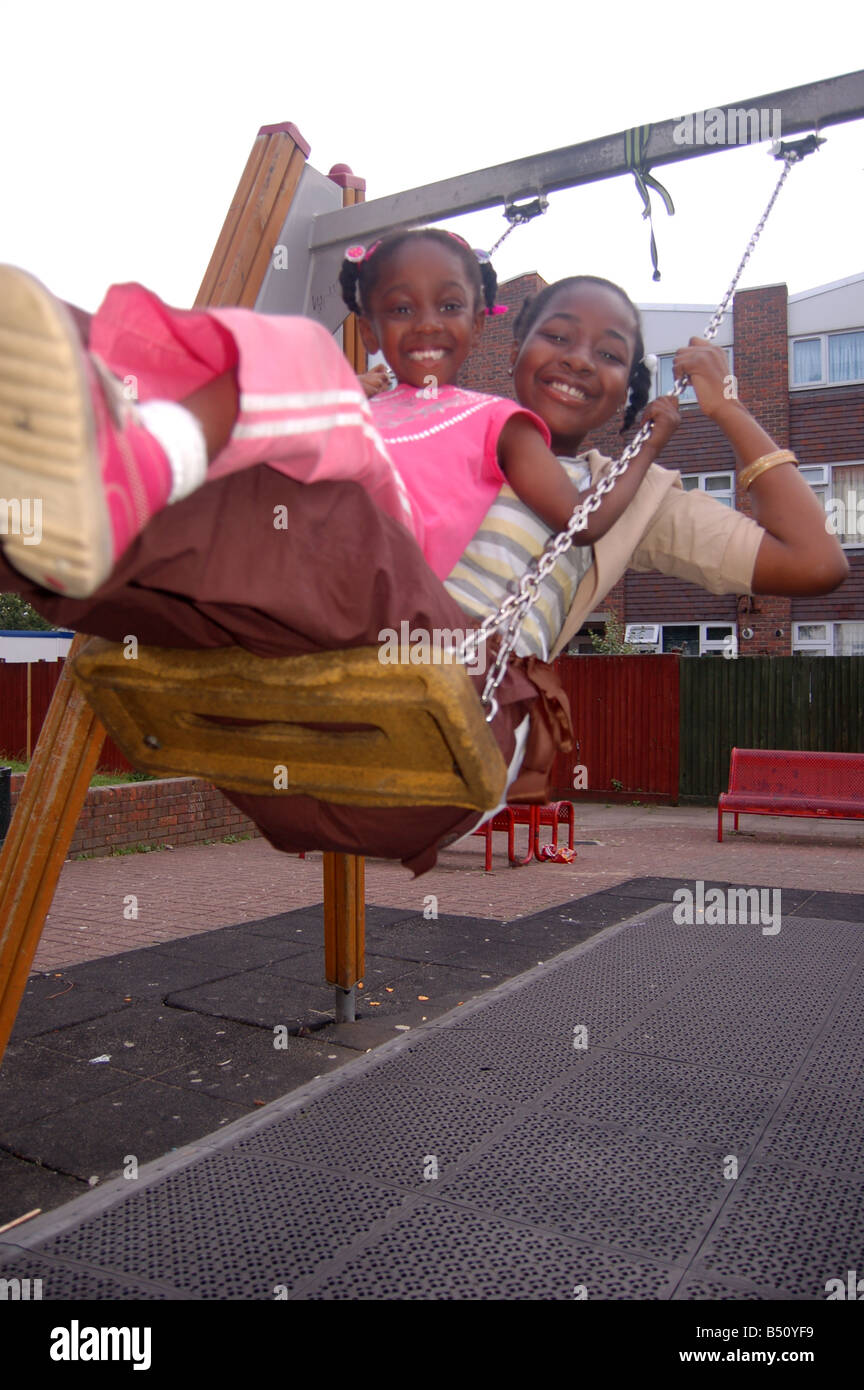Smiling afro-caraïbes enfants on swing Banque D'Images