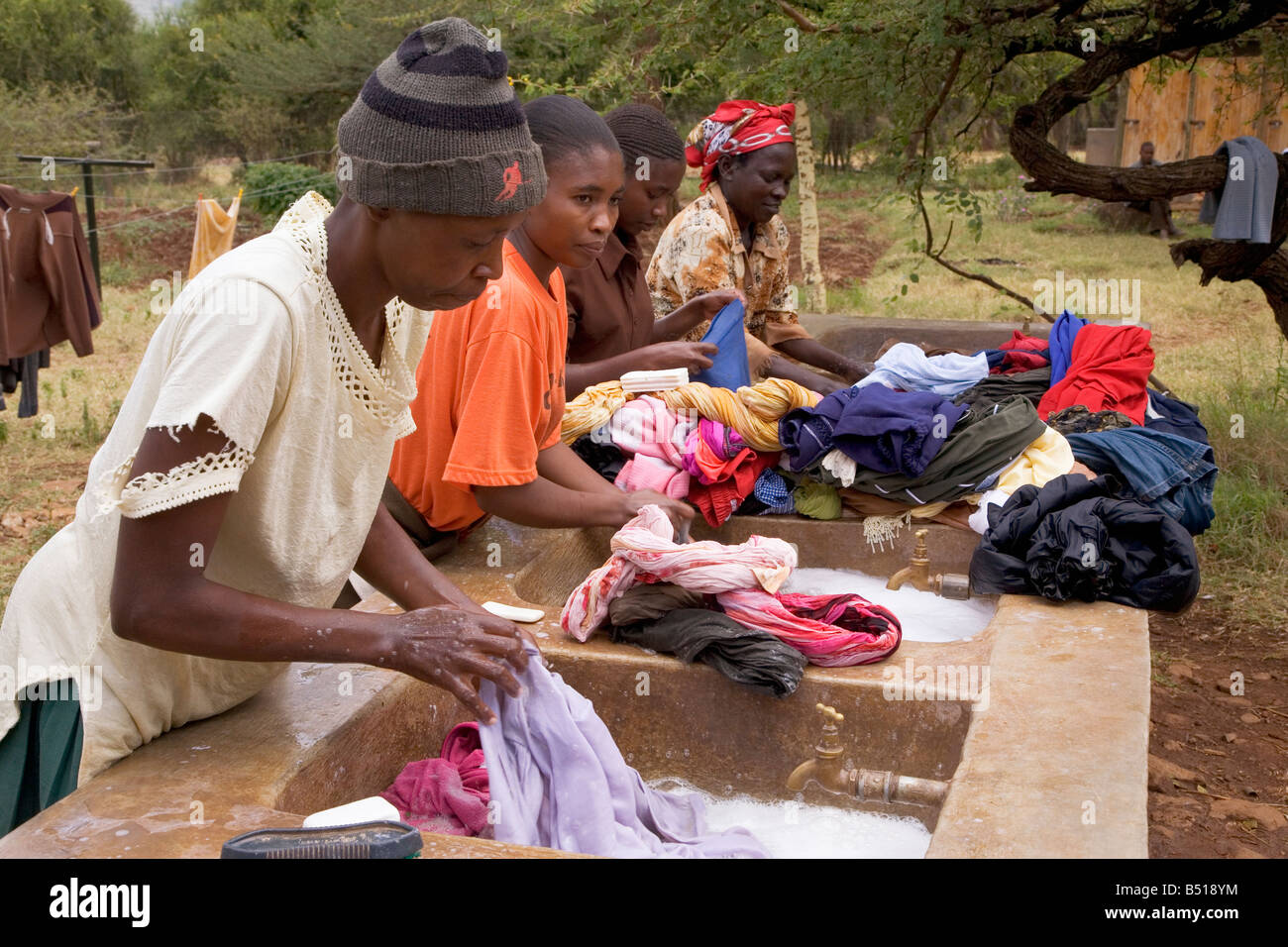 Les Africains laver leurs vêtements dans les éviers fournis par un organisme de bienfaisance local ; près de Isiolo, Kenya, Afrique de l'Est. Banque D'Images