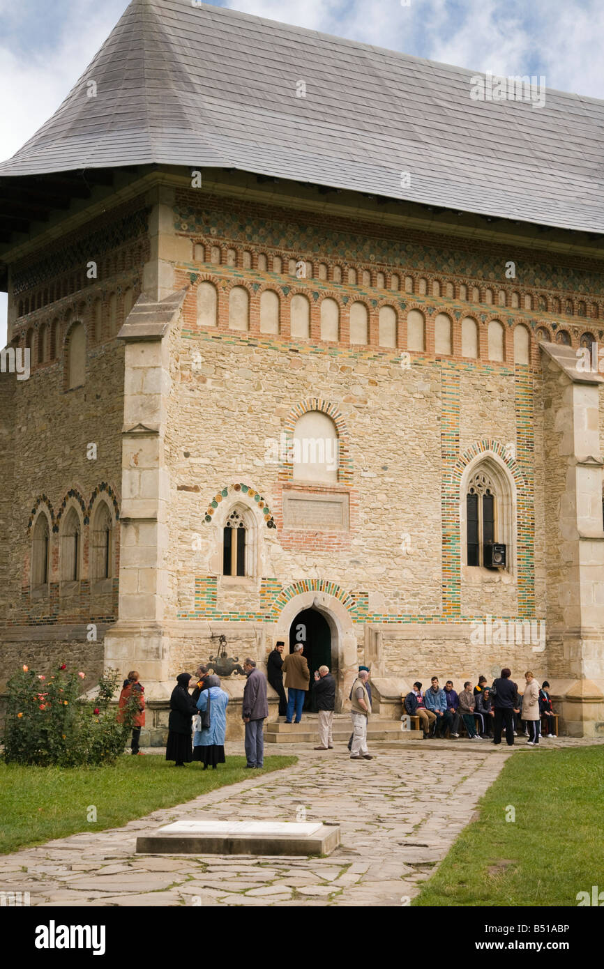 La Moldavie Roumanie les touristes à l'extérieur de l'église médiévale du 15e siècle à l'intérieur de motifs quadrant de 14e siècle Monastère Neamt Banque D'Images
