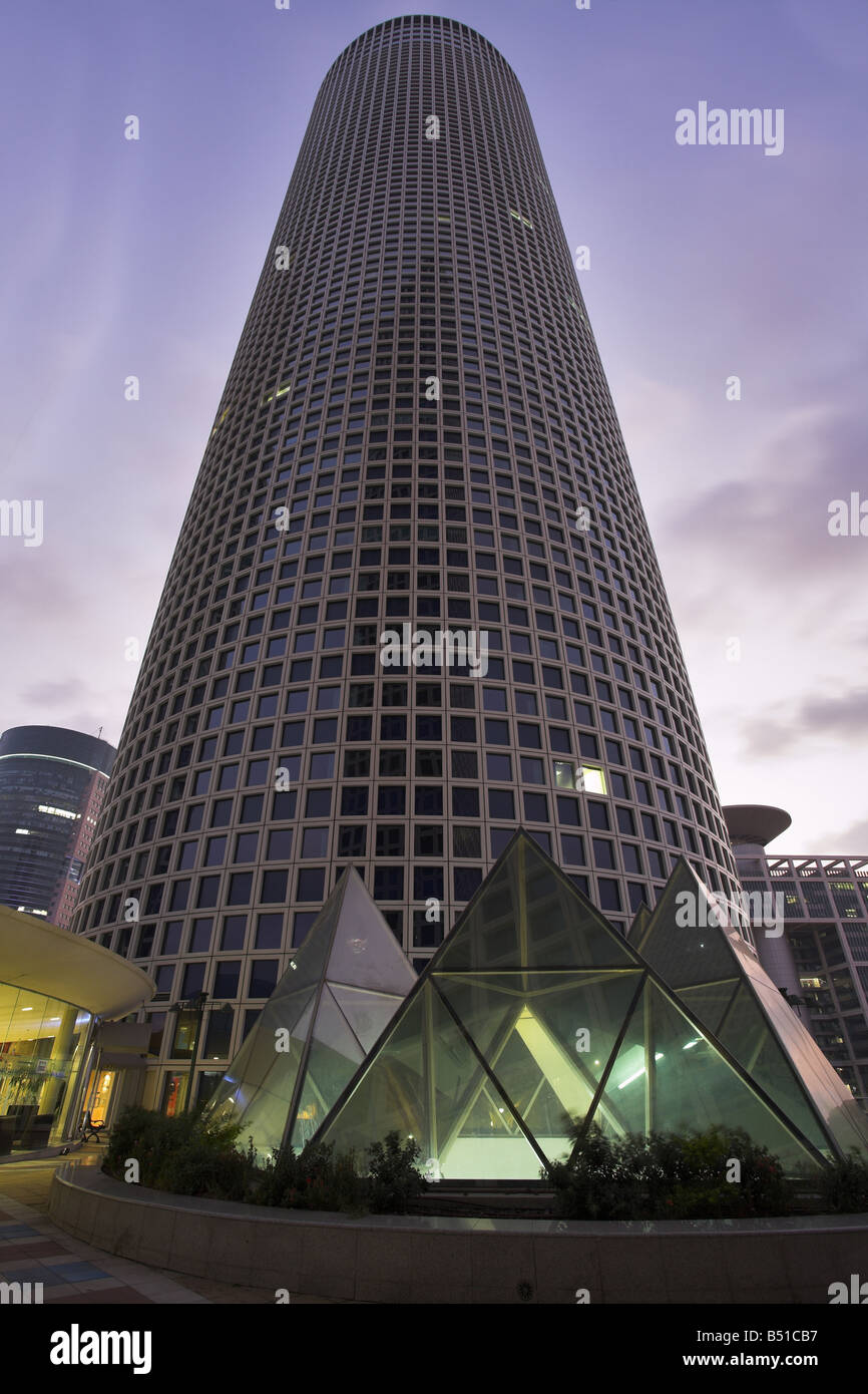 Gratte-ciel de la forme ronde inhabituelle dans la partie affaires Tel Aviv sur un fond de nuages soir rose Banque D'Images