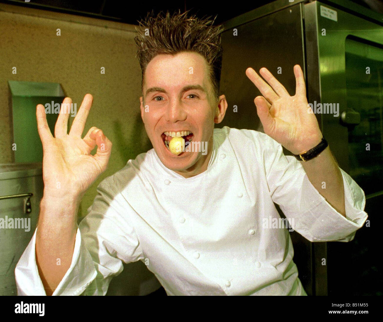 Gary Rhodes avec des pommes de terre à l'intérieur de sa bouche dans la cuisine Banque D'Images