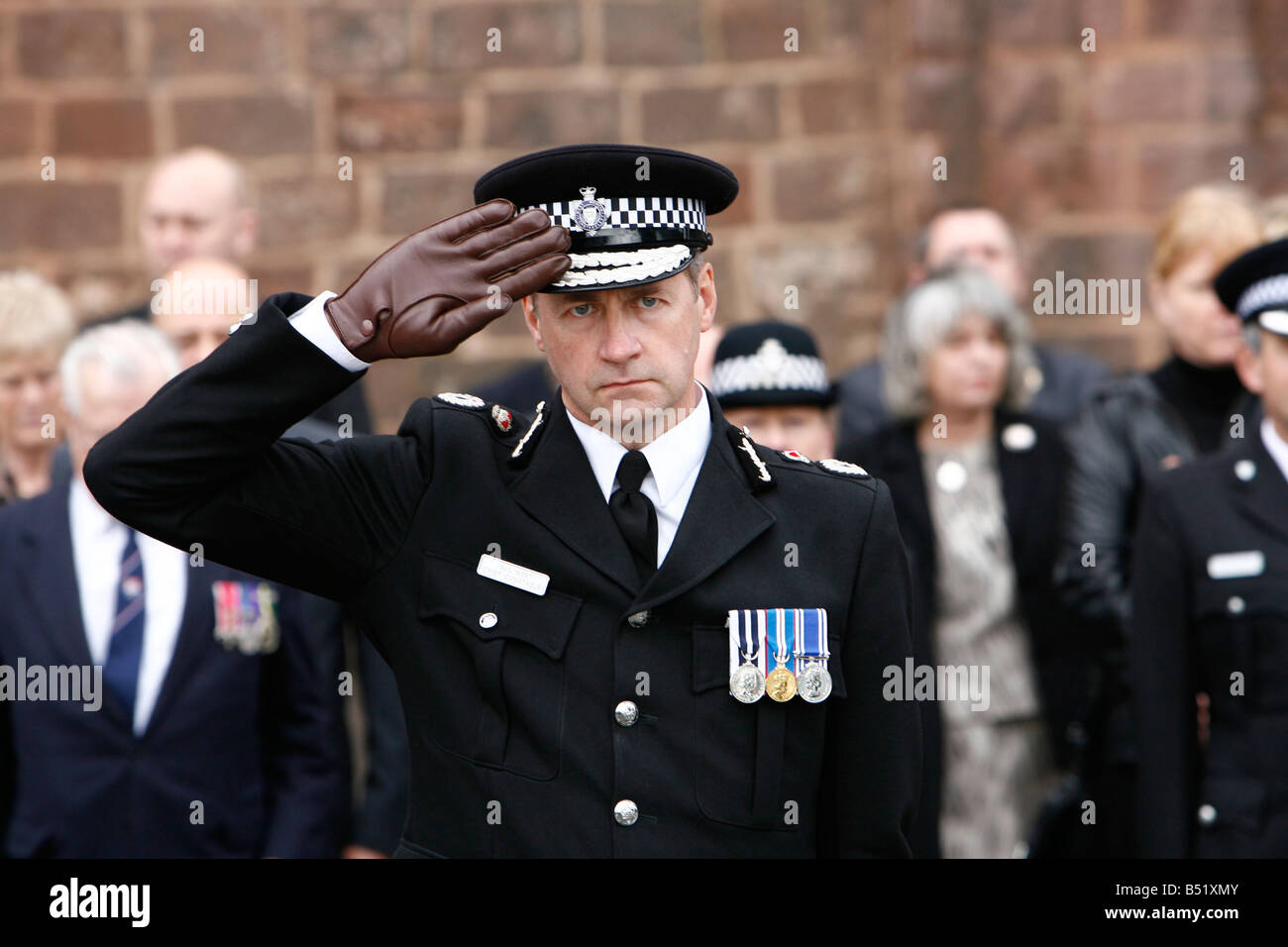 Directeur de la police Paul West salue PC Richard Coffin gris comme il passe par l'abbaye de Shrewsbury après ses funérailles. Banque D'Images