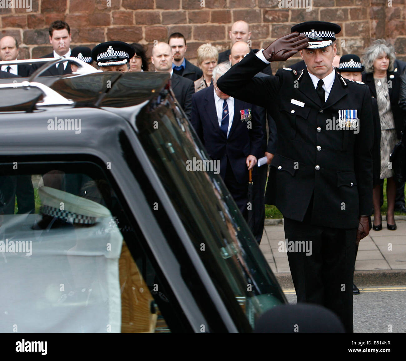 Directeur de la police Paul West salue PC Richard Coffin gris comme il passe par l'abbaye de Shrewsbury après ses funérailles. Banque D'Images