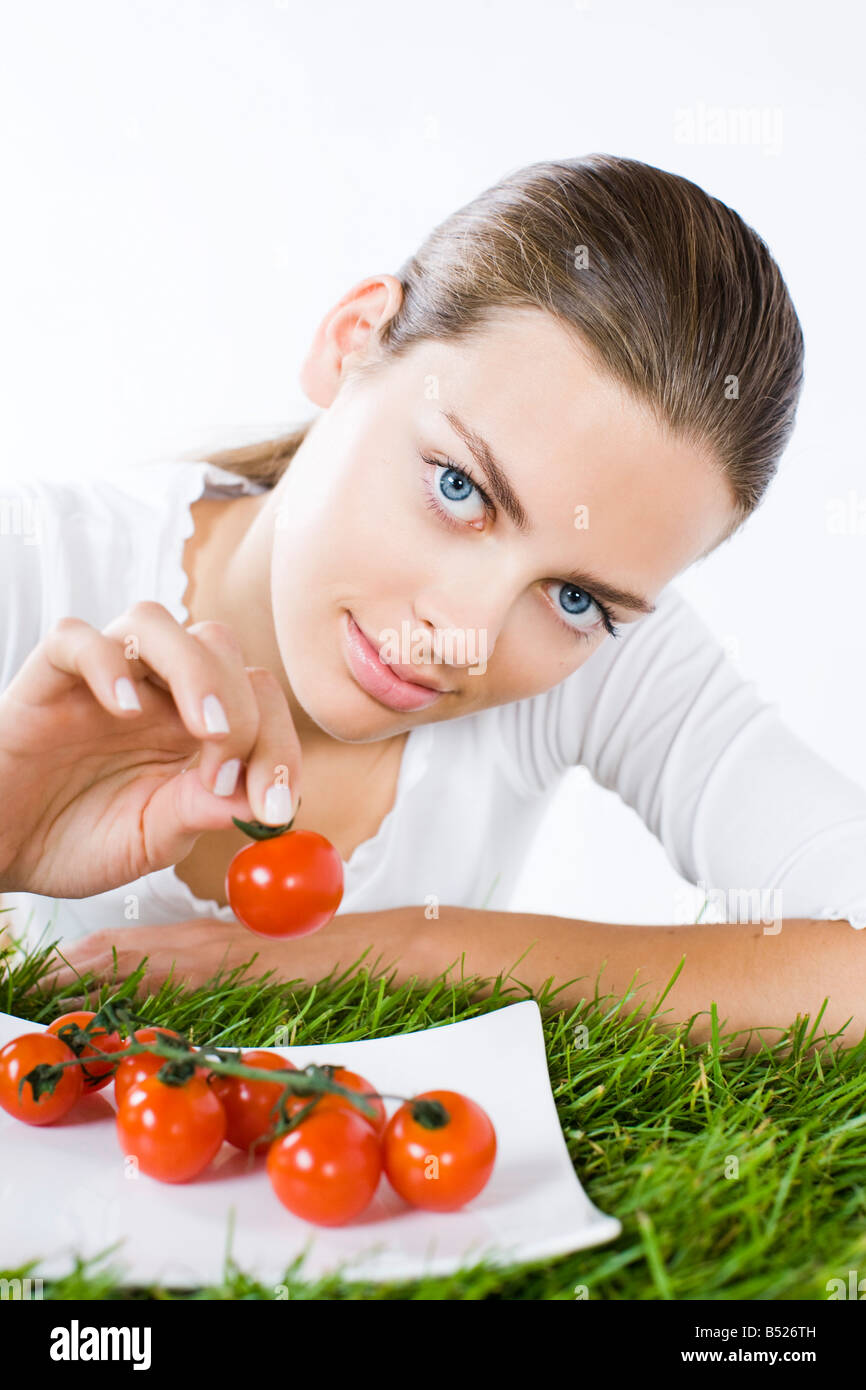Woman eating cherry tomatoes Banque D'Images